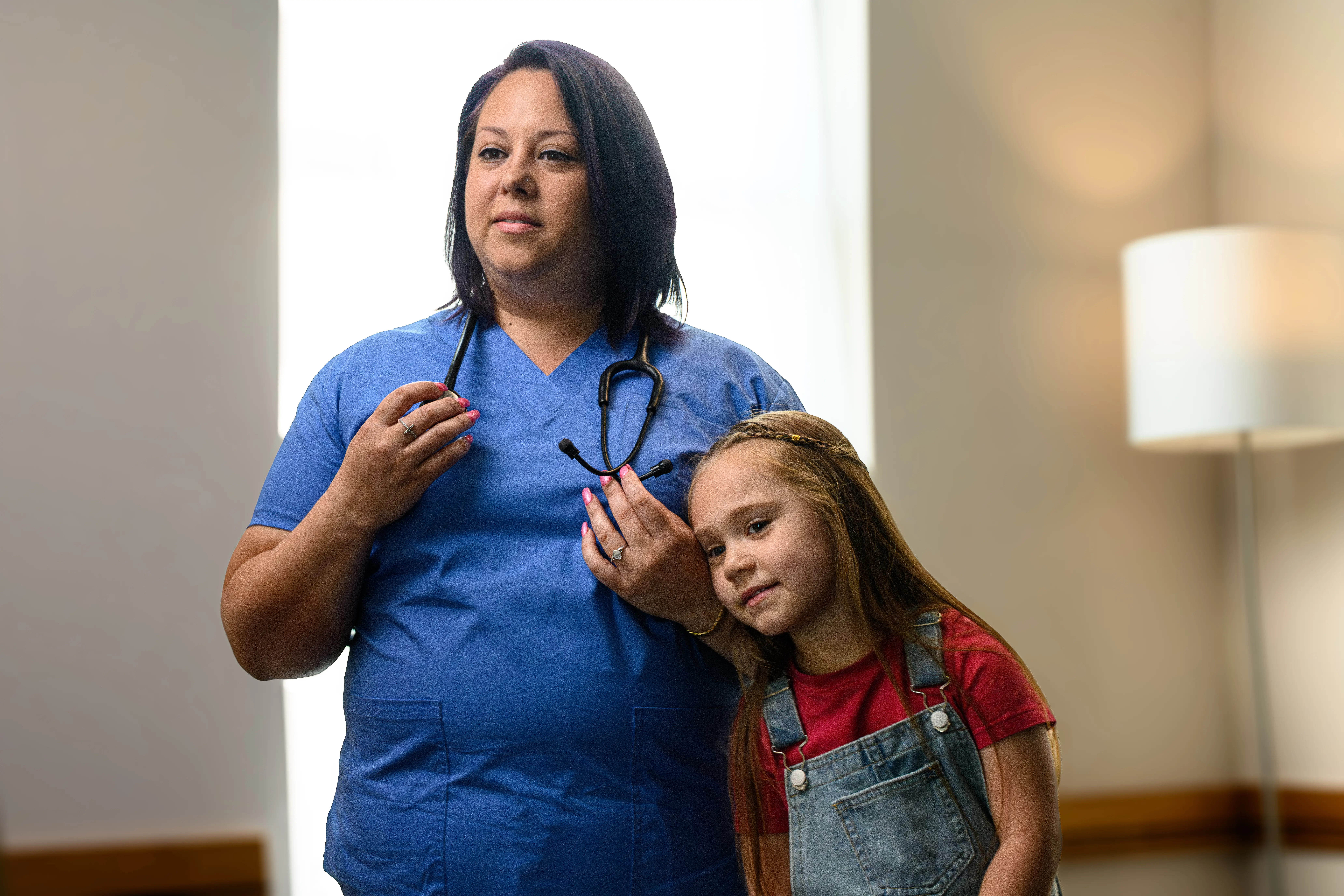 New graduate proudly wearing her scrubs with her daughter
