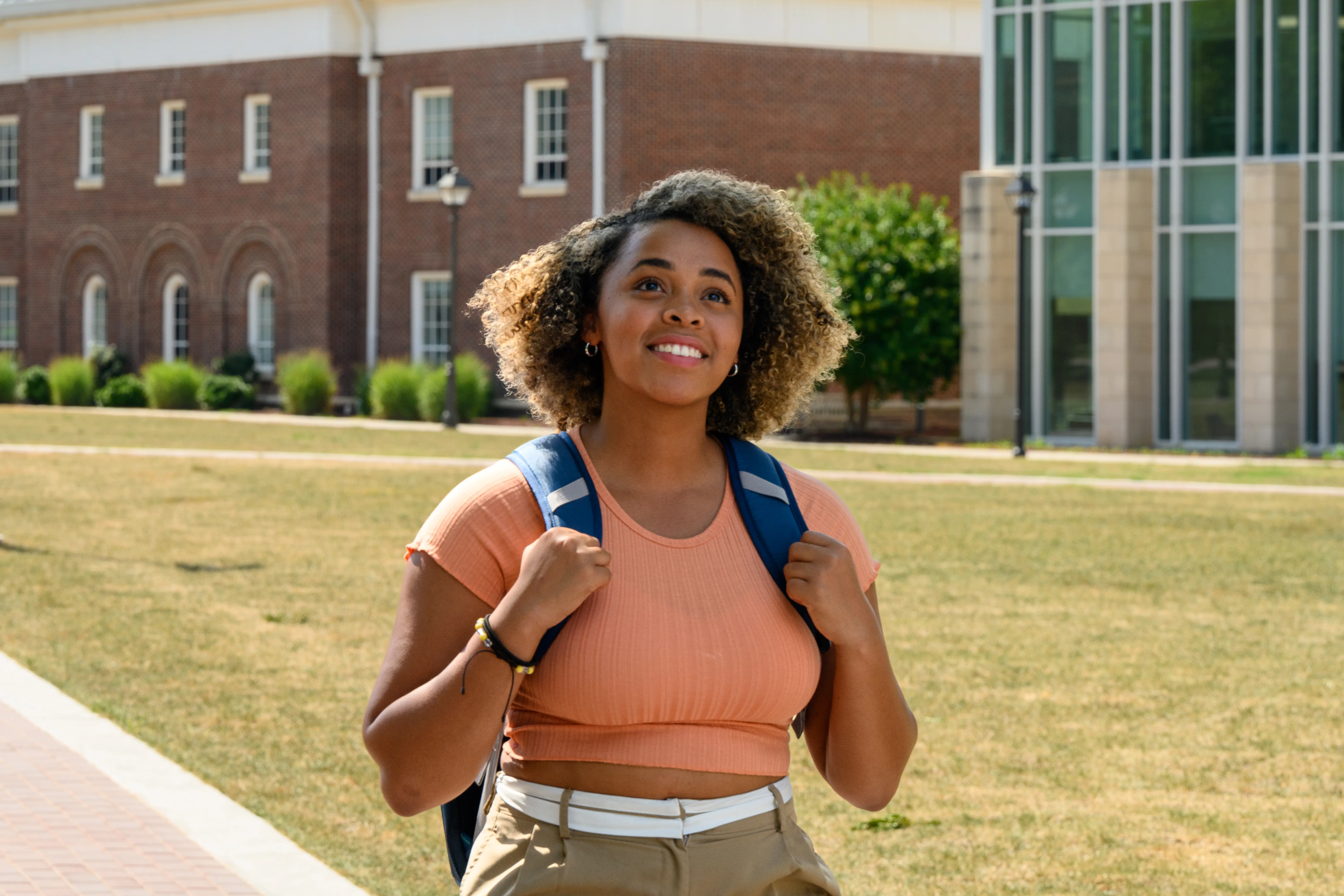 Happy female college student walks to class