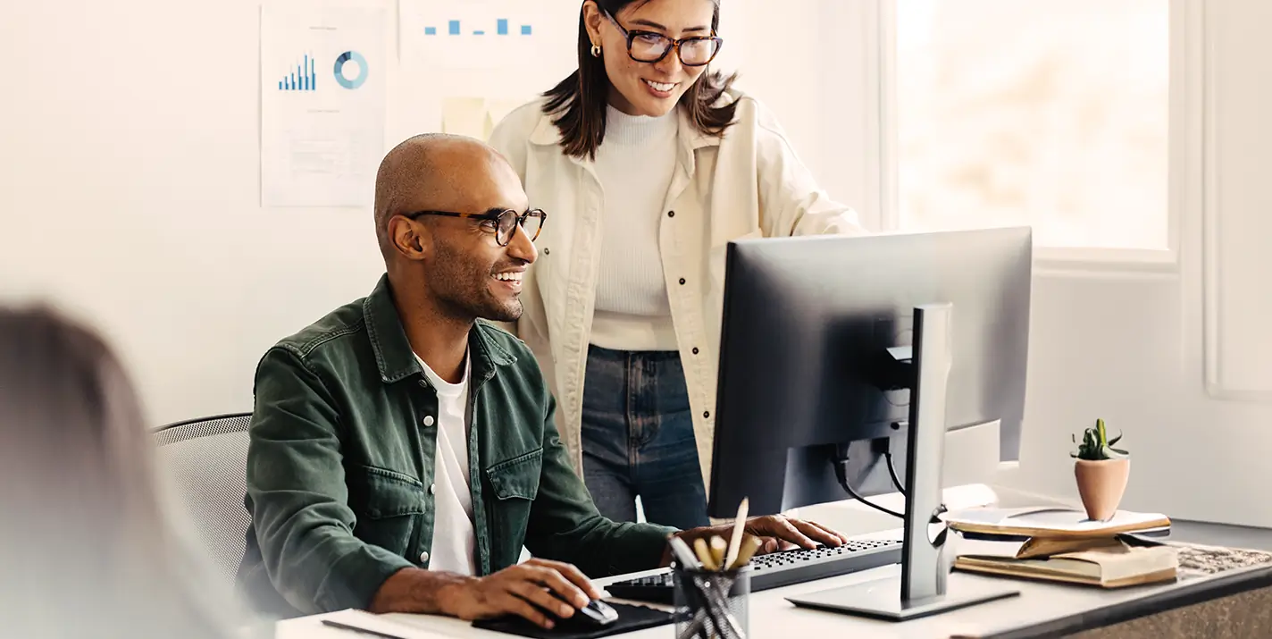 Two co-workers collaborating on a computer