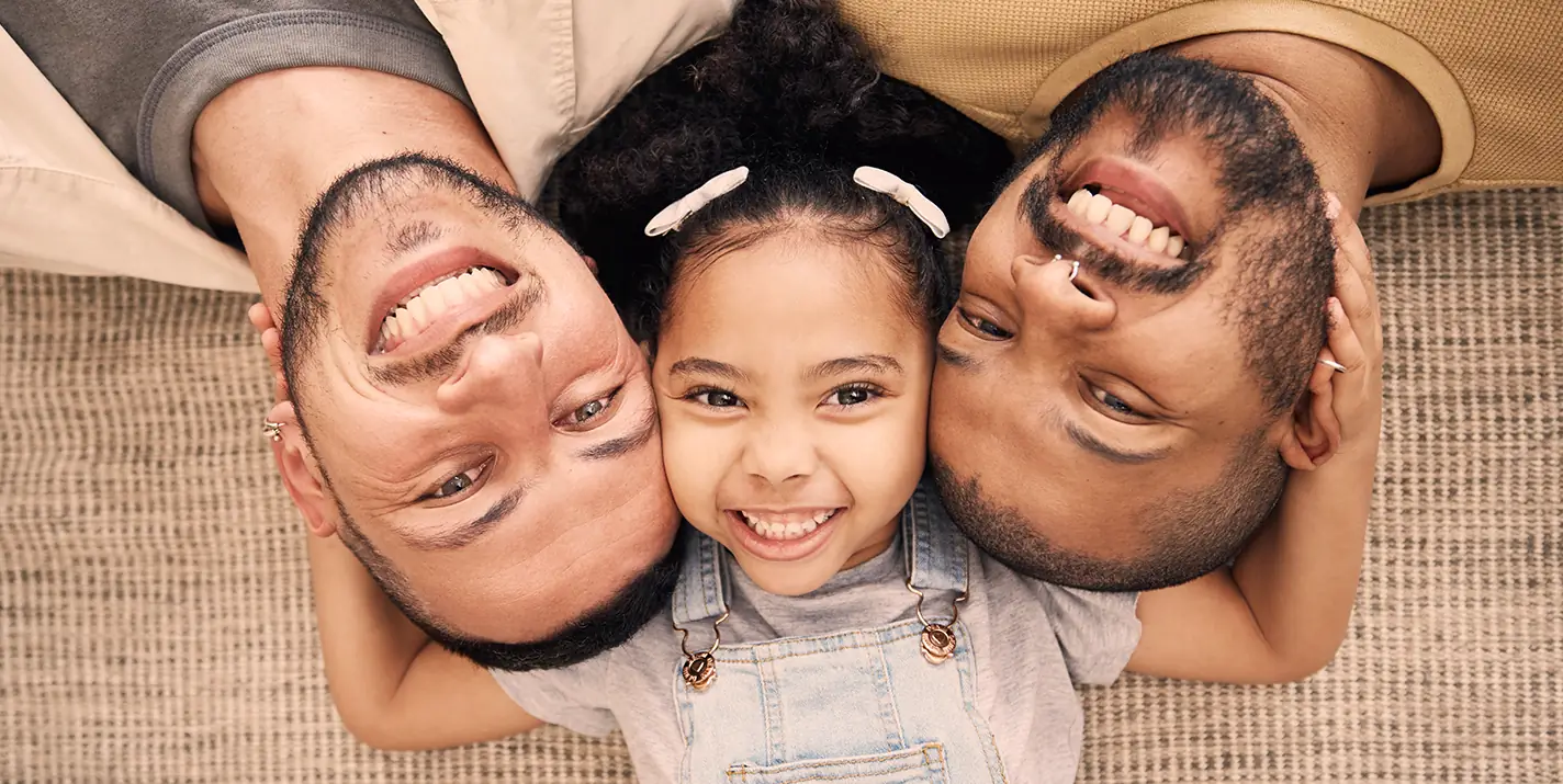 Two men and a child smiling at the camera