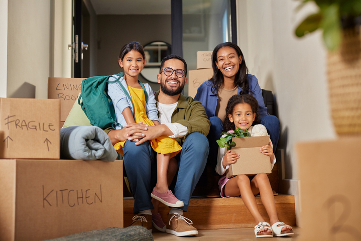A family of four is shown in the process of moving into a new home.